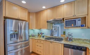 Enjoy cooking in this well-equipped kitchen with a refrigerator, microwave, stove, and dishwasher.