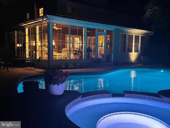 Enjoy an and luxurious setting with a large glass-enclosed porch and a swimming pool with hot tub.
