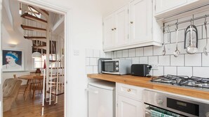 A kitchen with white cabinets, a microwave, a toaster, and a gas stove. - Large Shoreditch 2/dbl bed Loft apt (London)