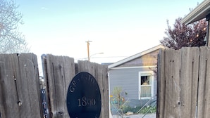 A wooden gate with a plaque reading "GRAYSTONE COTTAGE 1890" leading to a paved pathway. - 1890 Graystone Cottage behind Historic Home short walk to Downtown & Whiskey Row (Prescott)