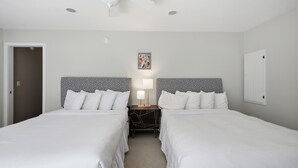 A hotel room with two beds, a ceiling fan, a nightstand with a lamp, and a framed picture on the wall. - Union Pier Home Walking Distance To Beach With Hot Tub! (Union Pier)