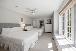 A bedroom with two beds, a ceiling fan, a dresser, and large windows. - Union Pier Home Walking Distance To Beach With Hot Tub! (Union Pier)
