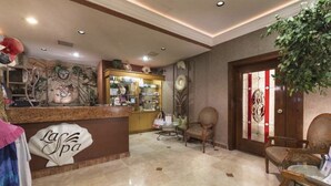 A spa reception area with a counter, chairs, and a decorative wall. - Beachfront Lower Floor Luxury Condo (Puerto Peñasco)