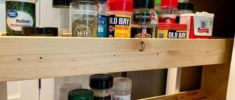 A shelf with various seasoning jars and containers.