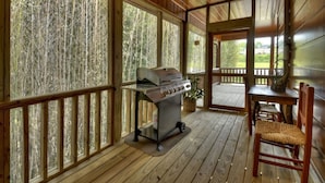 A covered outdoor area with a grill, wooden deck, and a table with chairs. - Downtown Lodge Blue Ridge, sleeps 14,walk to strip (Blue Ridge)