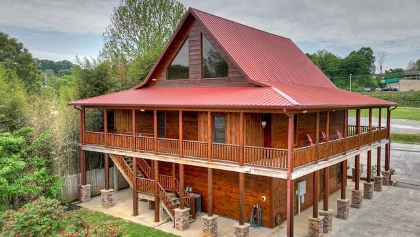 A two-story wooden cabin with a red roof, a balcony, and a staircase leading to the upper floor. - Downtown Lodge Blue Ridge, sleeps 14,walk to strip (Blue Ridge)