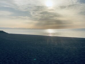 A beach with calm water and a clear sky.