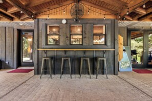 Relax with a drink at the bar, surrounded by exposed beams and a large window.