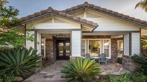 A house with a stone facade, a covered porch, and a front door.