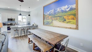 A modern kitchen with white cabinets, a central island, and pendant lighting.