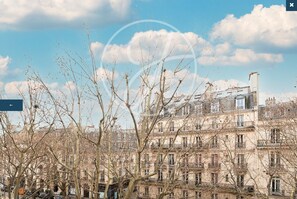 A multi-story building with a classic architectural style, featuring numerous windows and balconies. - Charming apartment in the heart of Saint-Germain (Paris)