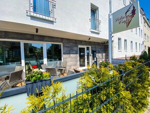 A modern building with a cafe named 'Lilien Cafe' on the ground floor. - Limok Rooms (Leipzig)