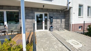 Un edificio con área de patio, un contenedor de basura y una cámara de seguridad.