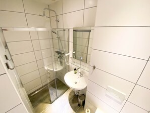 Driepersoonskamer | Badkamer | Een douche, een haardroger, handdoeken