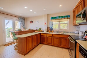 A kitchen with wooden cabinets, a water dispenser, a microwave, and a toaster.