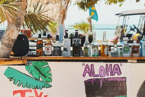 A bar with various liquor bottles and a sign with 'ALOHA' written on it.