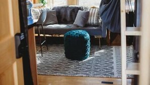 Ein gemütliches Blockhaus-Interieur mit Sofa, Hocker und Hängesessel.