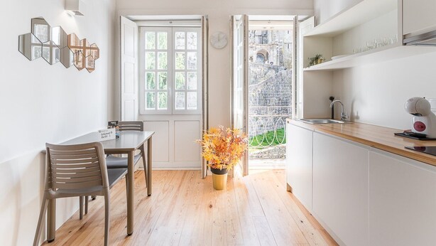 Une cuisine moderne avec une table à manger en bois, une plante en pot et un four encastré.