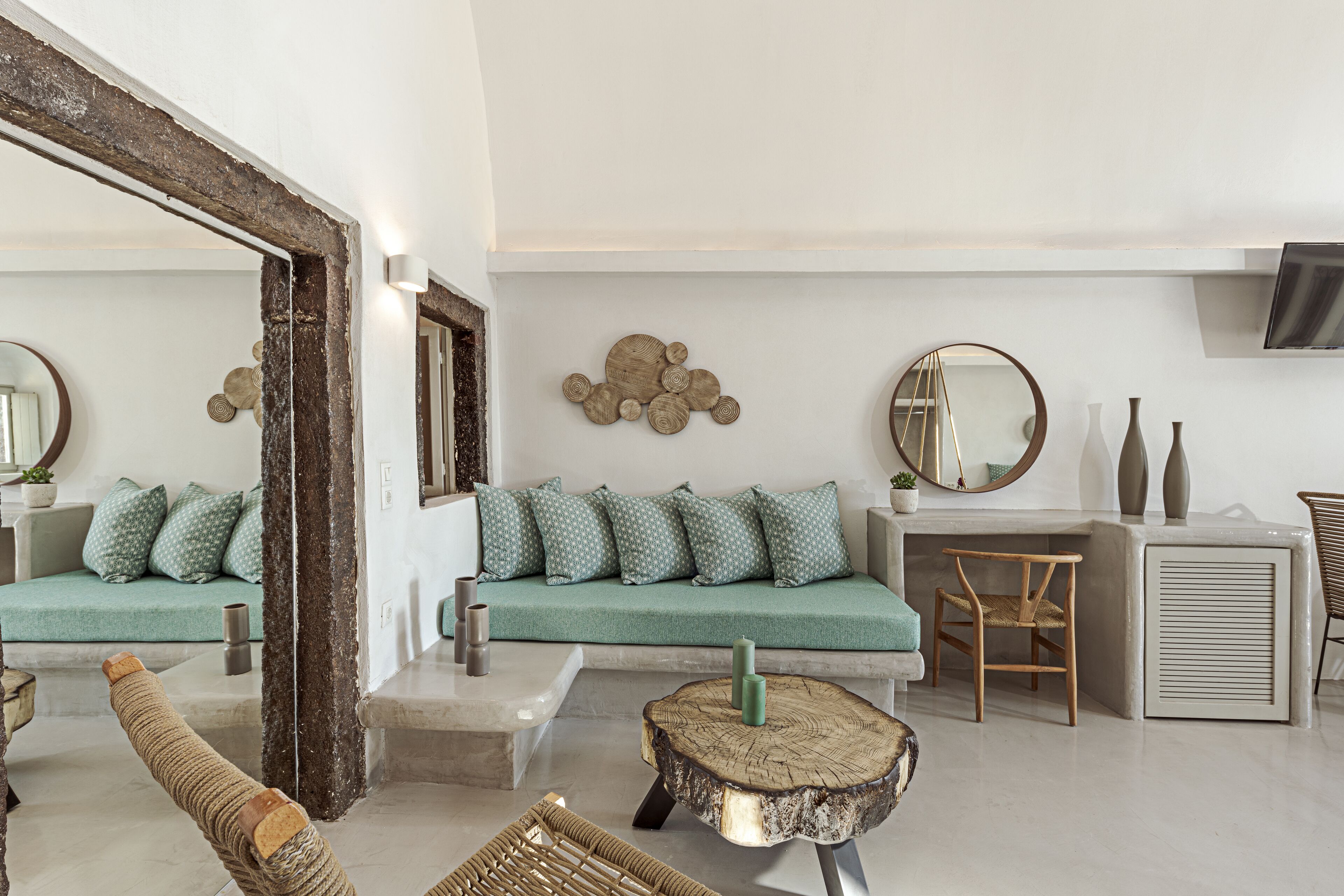 Un salon moderne avec un canapé vert, une table basse en bois et un grand miroir.