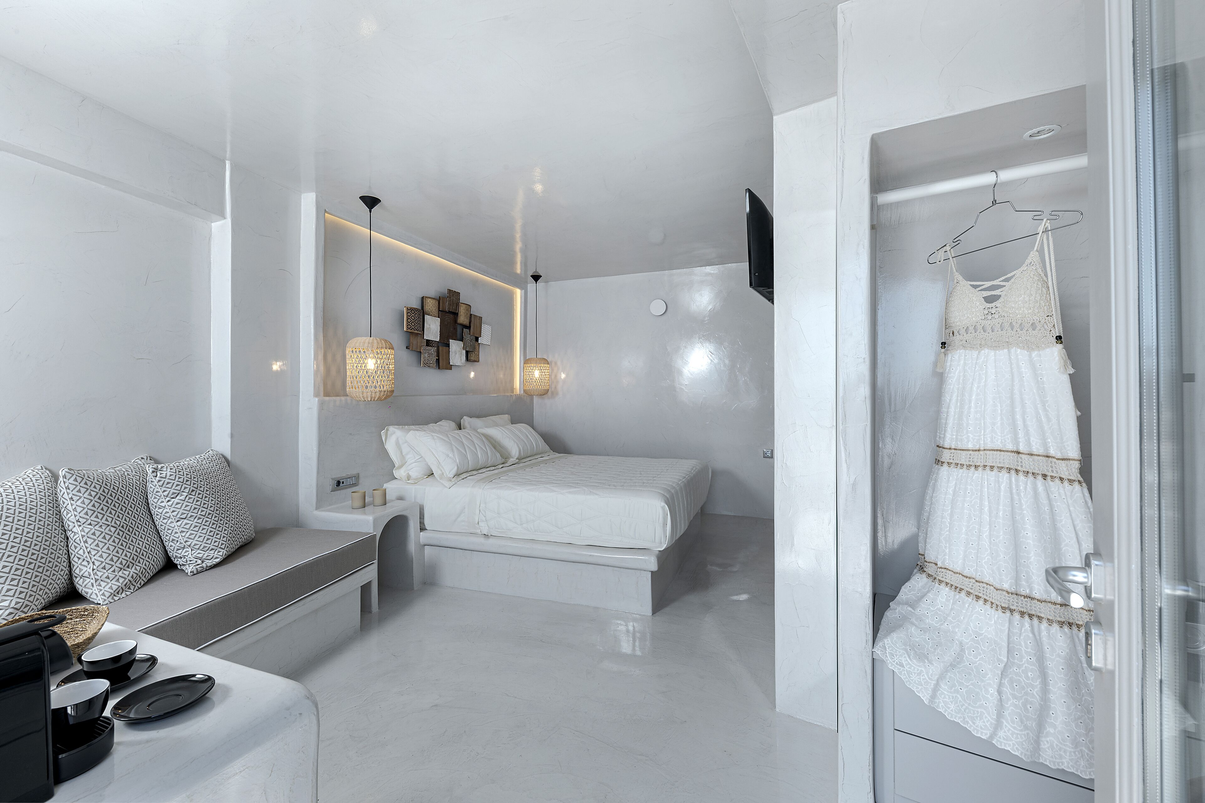 Une chambre à coucher moderne avec un lit, une table de chevet et une robe suspendue.