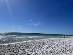 A beach with a sandy shore and a clear blue sky.