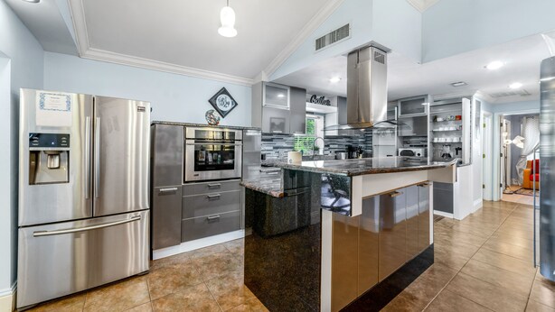 A modern kitchen with stainless steel appliances, a granite island, and a built-in oven. - Welcome to the Farm House! Excellent Location, Pet Friendly! (Windermere)