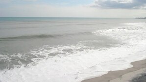 Een strand met golven die zachtjes op het strand spoelen.