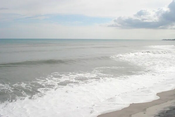 A beach with waves gently lapping onto the shore.