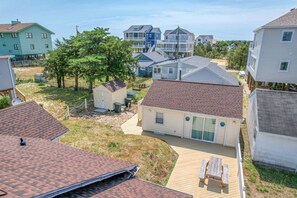 A residential area with houses, a wooden deck, and a small shed.