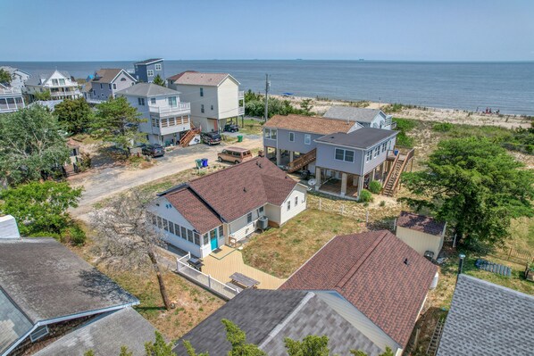 A coastal residential area with houses, a sandy beach, and the ocean in the background. - "STEPS TO SAND - Two Cottage Classic Gem Retreat" (Milton)
