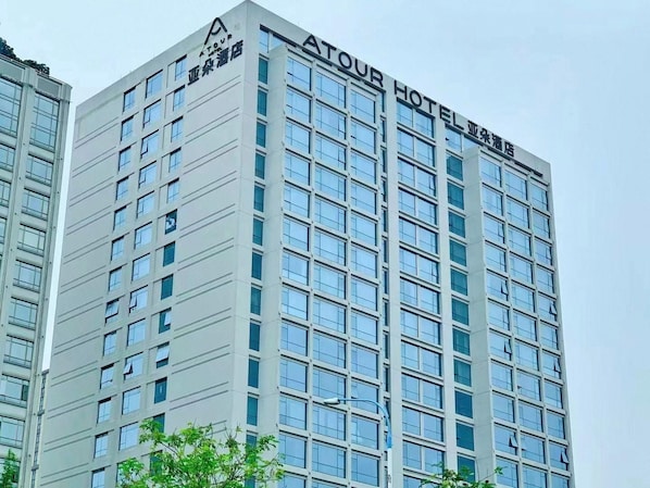 Un edificio de hotel de varios pisos con un diseño arquitectónico moderno, que presenta un letrero llamativo en la parte superior.