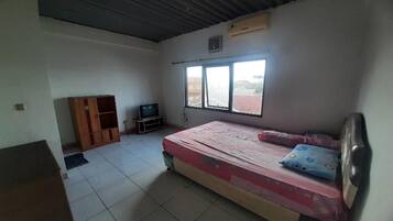 A room with a bed, a TV, a wardrobe, and a window.