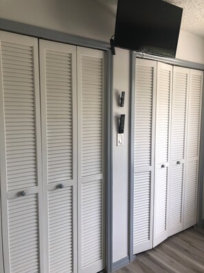 A set of white louvered closets with a remote control on the wall. - Cute renovated 2 bedroom condo just minutes from Sanibel (Fort Myers)