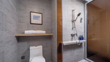 Ein modernes Badezimmer mit Toilette, Dusche und einem gerahmten Bild an der Wand.