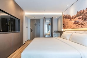 A modern hotel room with a large bed, a wardrobe, a mirror, and a painting on the wall. - Shanghai Baoshan Changjiang Road Atour Light Residence Hotel (Shanghai)