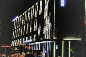 Un hotel de varios pisos con señalización iluminada y fachada moderna.
