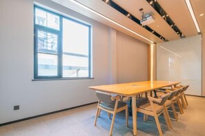 A conference room with a long table, chairs, a projector, and a large window. - Shanghai Baoshan Changjiang Road Atour Light Residence Hotel (Shanghai)
