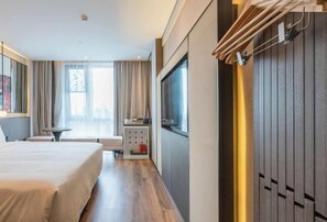 A hotel room with a bed, a TV, a desk, and a window with curtains. - Shanghai Baoshan Changjiang Road Atour Light Residence Hotel (Shanghai)