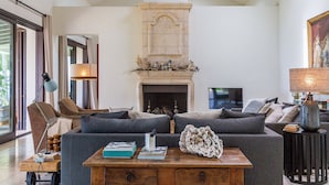 Una sala moderna con chimenea, un conjunto de sofás, una mesa de centro y una televisión.