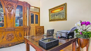 A wooden cabinet with glass doors, a framed picture on the wall, a desk with a laptop, printer, and potted orchid. - Hotel O New Bunga Sonsang Homestay Syariah (Padang)