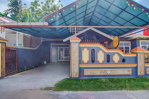 A building with a blue roof, a sign reading 'SPOT ON,' and a gated entrance. - Hotel O New Bunga Sonsang Homestay Syariah (Padang)