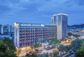 Un hotel Howard Johnson Club con fachada de vidrio moderna y una entrada destacada.