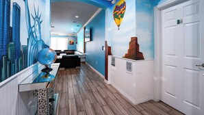 A hallway with a mural of the Statue of Liberty, a globe, and a hot air balloon. - Global Bowling Villa, 1GB wifi, video wall TV, private/heated pool, sleeps 34 (Davenport)