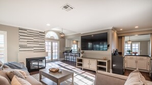 A modern living room with a sofa, coffee table, and a flat-screen TV.