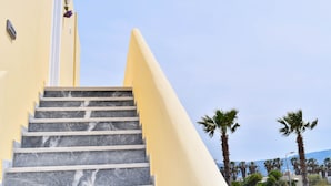 Eine Treppe mit Marmorstufen, die zu einem Gebäude mit gelber Fassade führt.