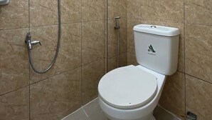 Ein Badezimmer mit Toilette, Dusche und einem Händetrockner.