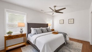 A bedroom with a bed, bedside tables, a ceiling fan, and a window with blinds. - 4 bedroom pool home 1 block from the Beach! (Myrtle Beach)