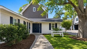 A two-story house with a front porch, a driveway, and a well-maintained lawn. - 4 bedroom pool home 1 block from the Beach! (Myrtle Beach)