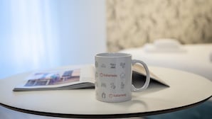 A white mug with travel-related icons and the text "italianway" on a round table.