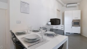 A modern kitchen with white cabinets, a microwave, and an oven. - Italianway Easy - Plinio 64 (Milan)